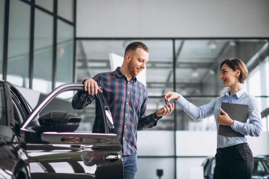 young handsome man choosing a car in a car showroom young handsome man choosing a car in a car showroom